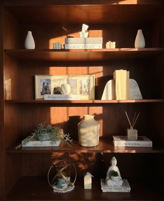 Styled walnut bookshelf with ceramics, books, and warm afternoon light