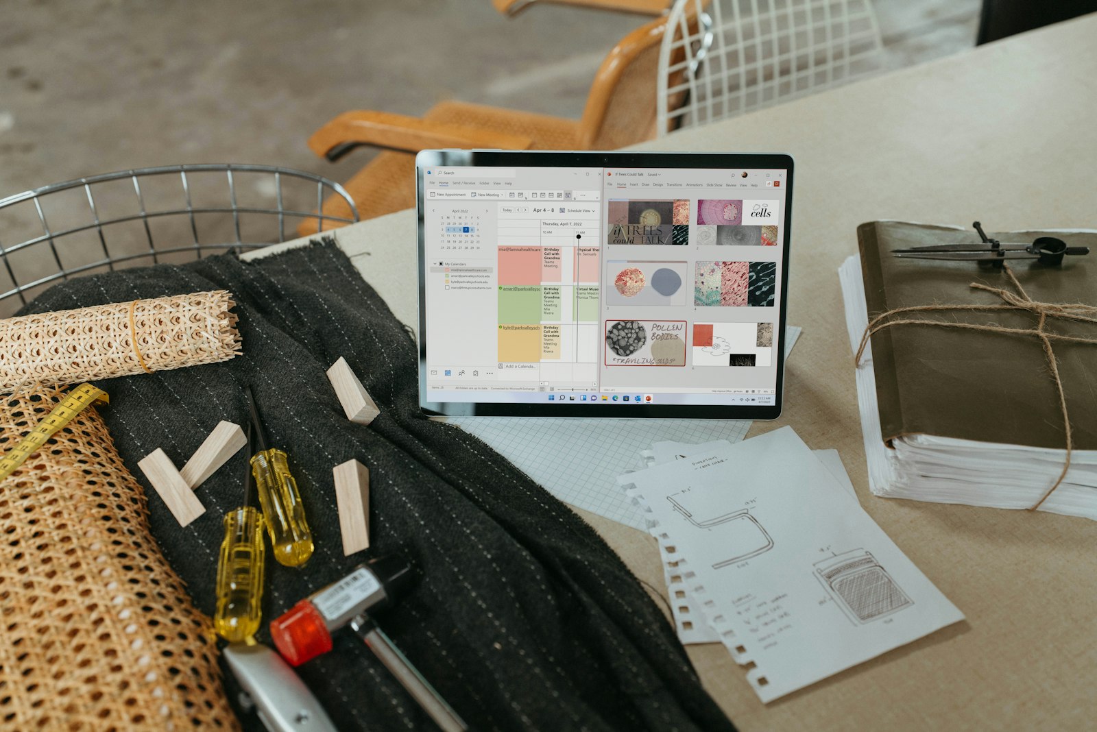 Laptop displaying a color and material mood board, surrounded by fabric samples and hand-sketched notes