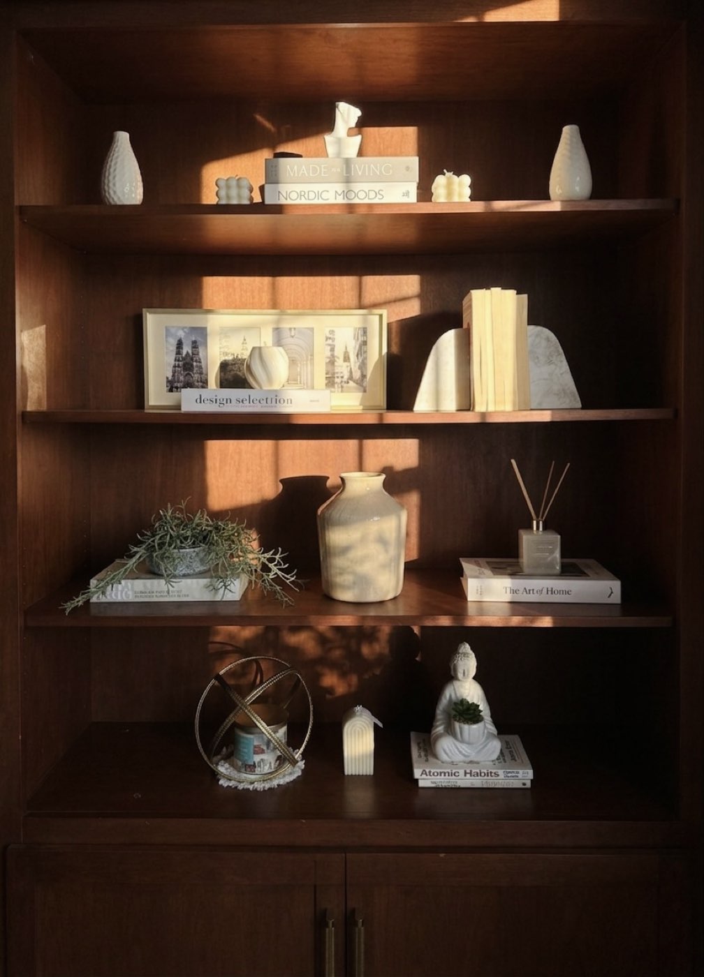 Sunlit walnut bookshelf styled with ceramics and books